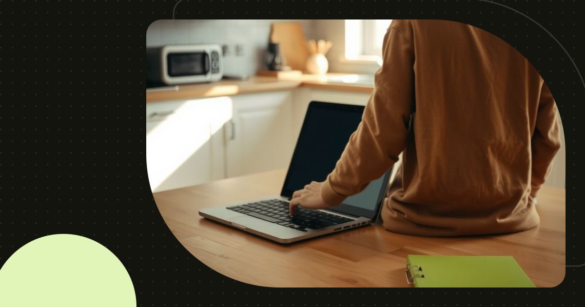 A person opening a laptop at a bright kitchen table beside a lime notebook